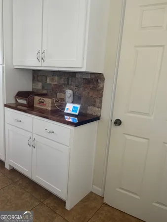 a kitchen with white cabinets and white appliances