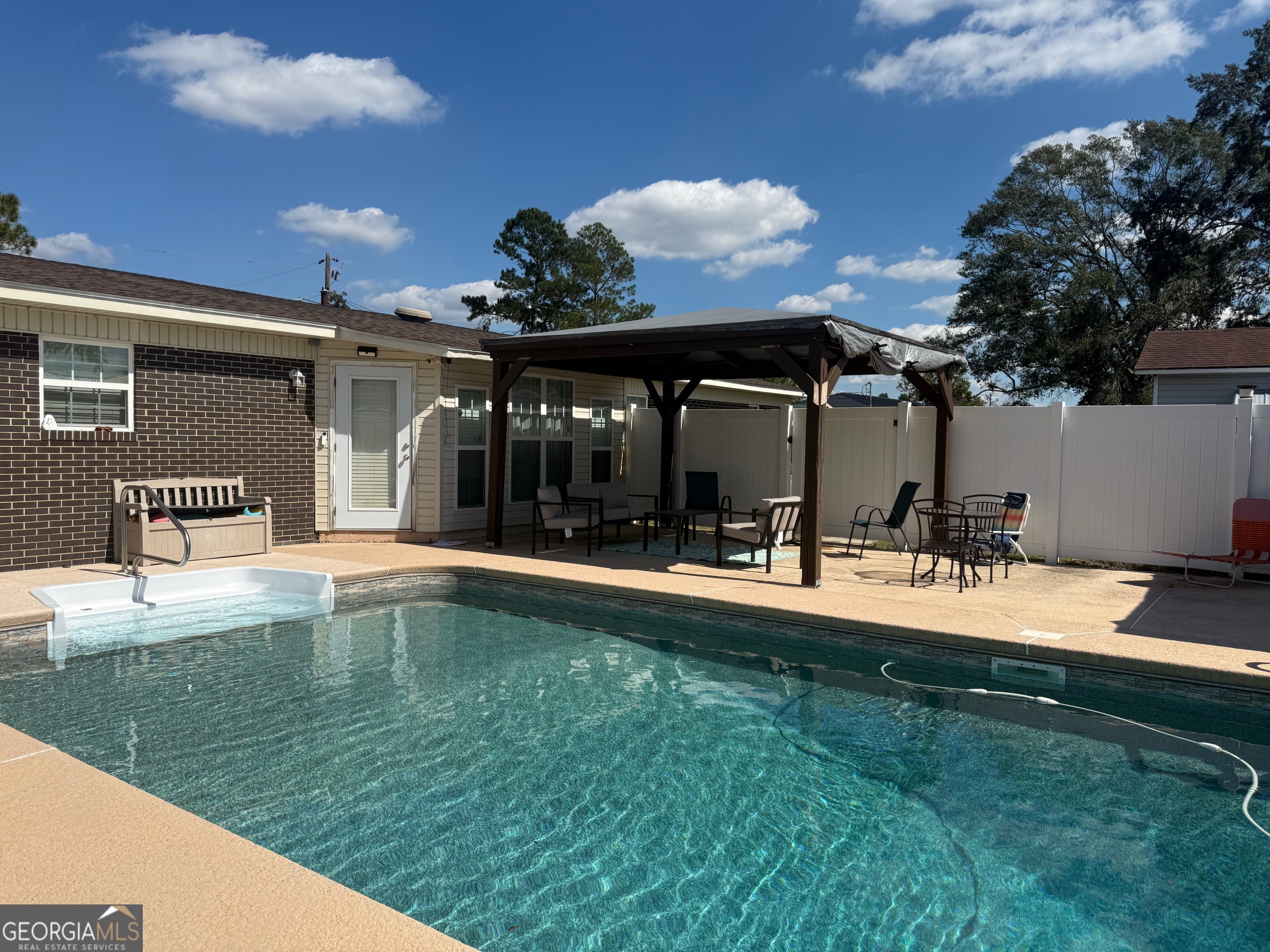 45 Elton Street Hazlehurst, GA 31539 - Photo 7 of 14 a view of a backyard with a table and chairs under an umbrella