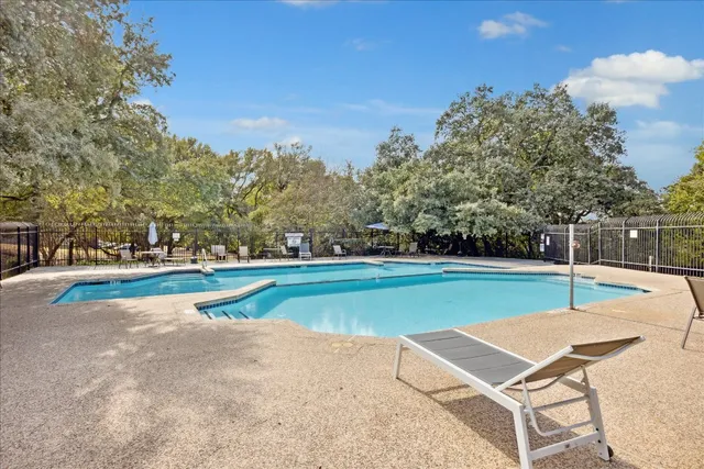 a swimming pool with trees in the background