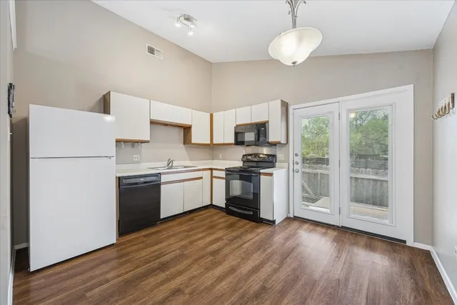 a kitchen with a refrigerator cabinets and wooden floor