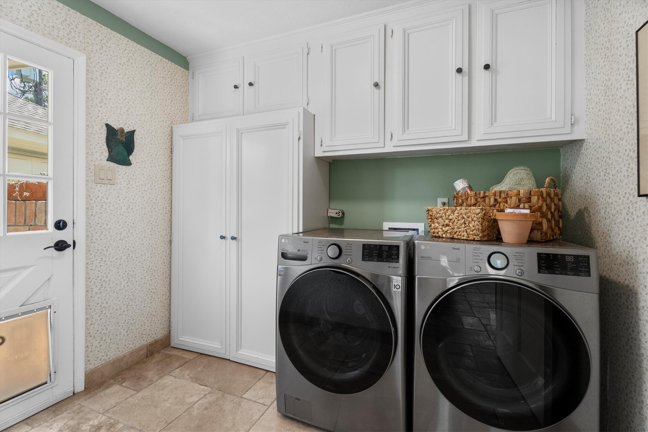 9103 Herts Road Spring, TX 77379 - Photo 19 of 46 A well-organized laundry room includes ample storage, tile flooring, and a door leading to the detached garage. Functionality and style in one space.