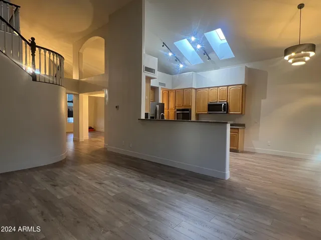 a view of a kitchen with a fridge and wooden floor