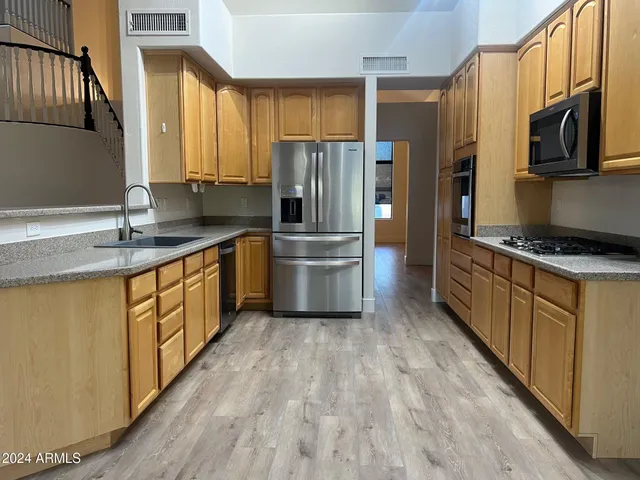 a kitchen with stainless steel appliances a refrigerator sink and stove