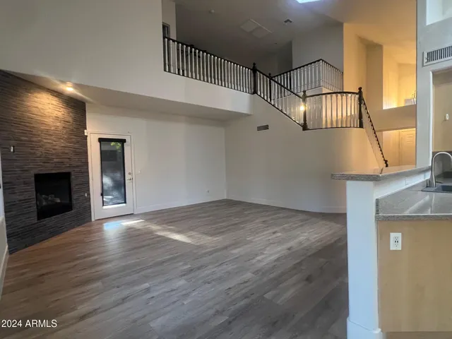 a view of empty room with wooden floor and fireplace