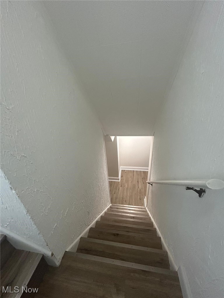 15410 Turney Road Maple Heights, OH 44137 - Photo 18 of 46 Staircase featuring a textured wall and wood finished floors