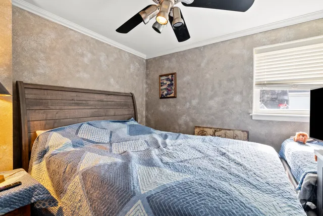 a bedroom with a large bed and a chandelier