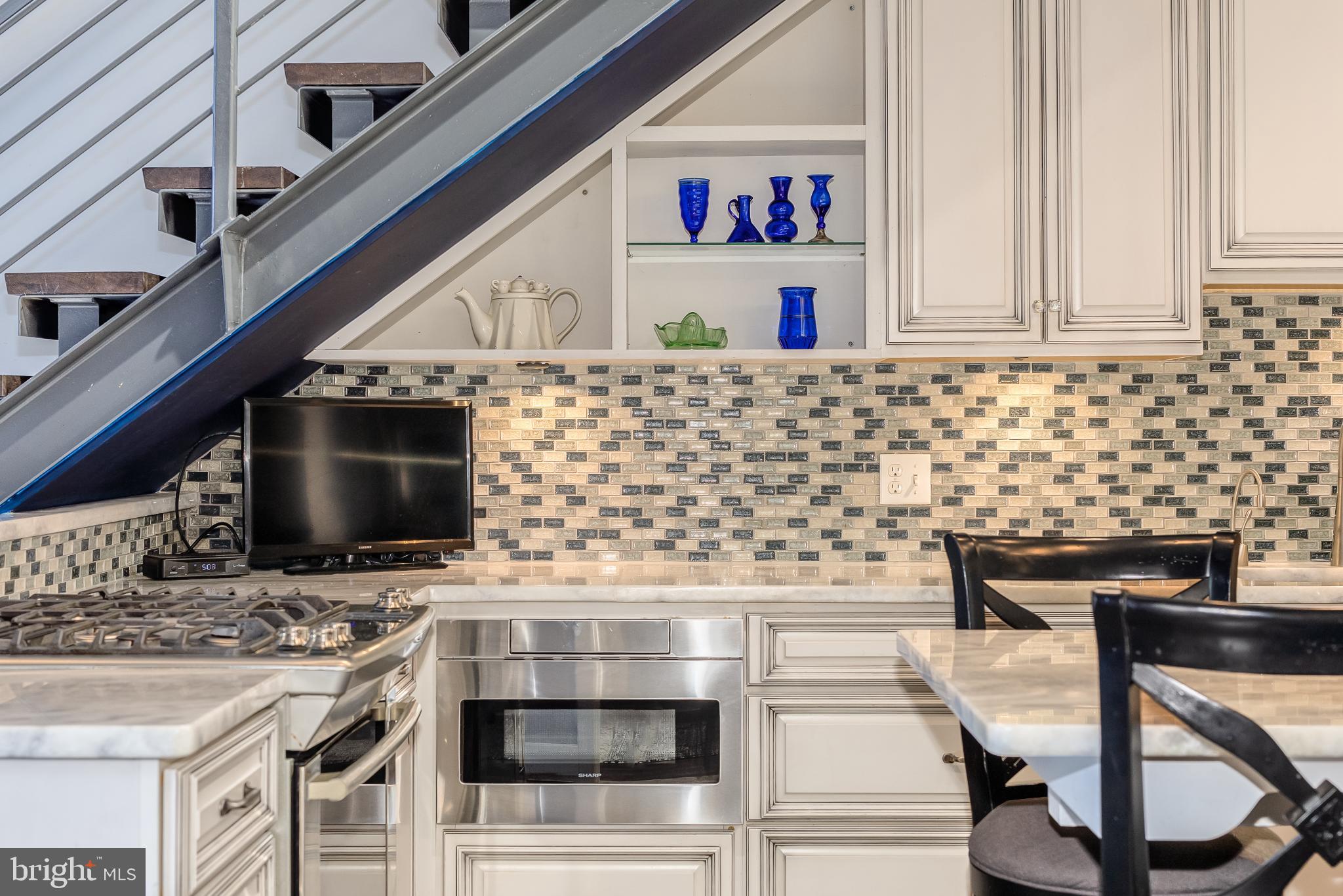 525 Water Street Southwest, Unit 403 Washington, DC 20024 - Photo 12 of 35 a kitchen with stainless steel appliances kitchen island granite countertop a stove and a microwave