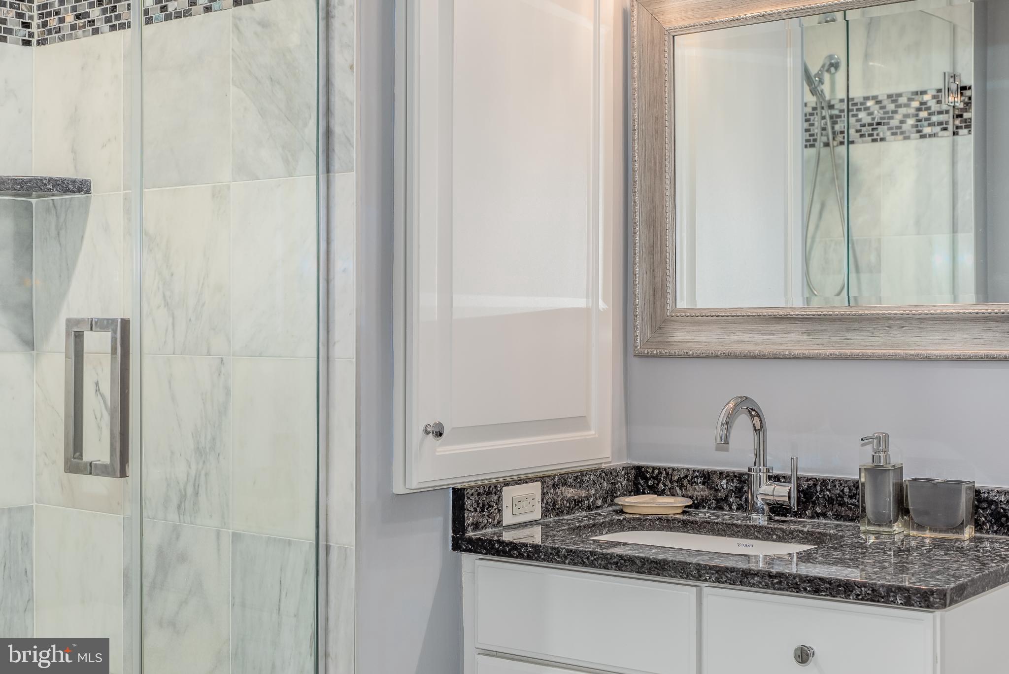 525 Water Street Southwest, Unit 403 Washington, DC 20024 - Photo 16 of 35 a bathroom with a granite countertop sink and a mirror