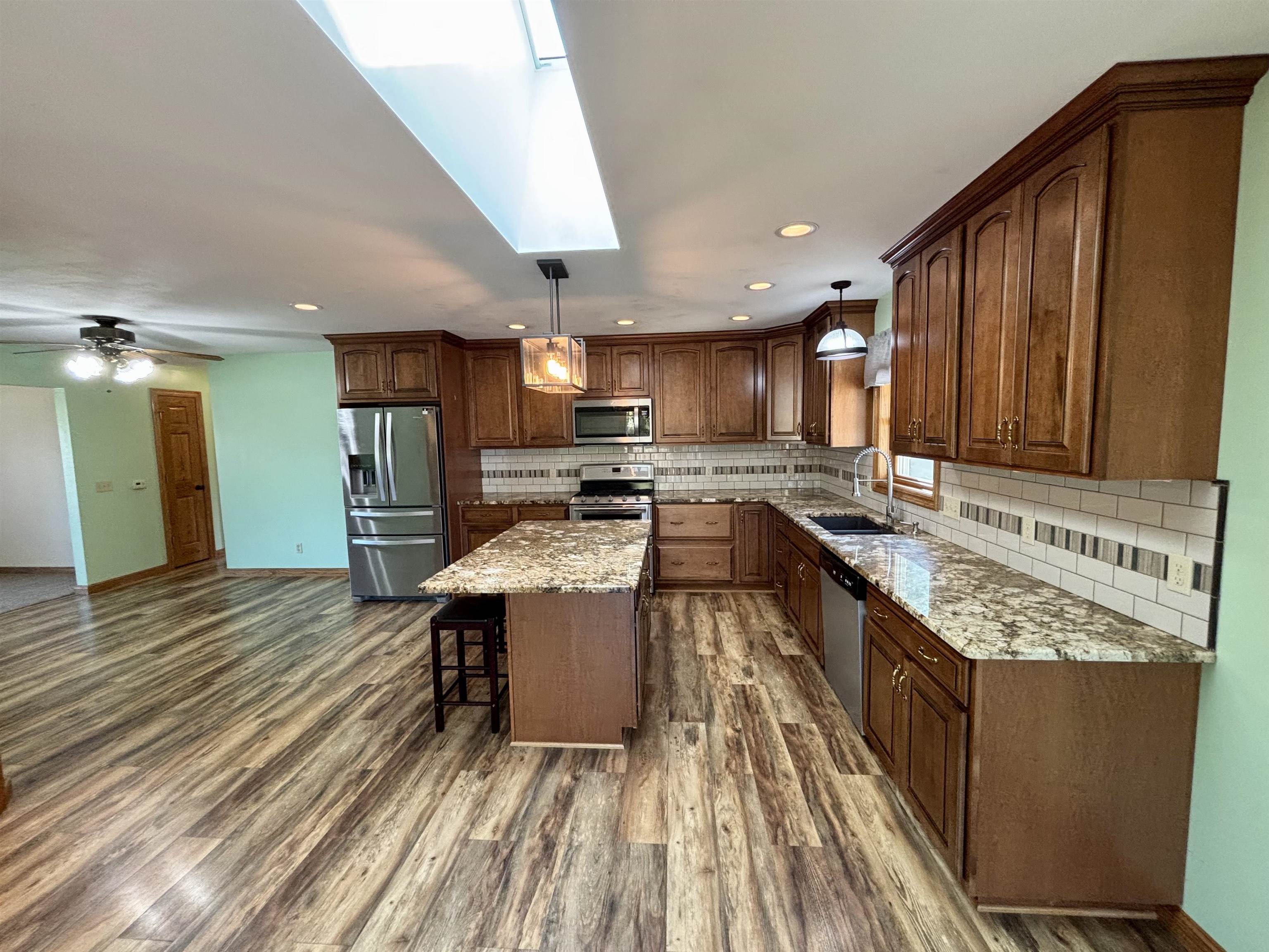 3310 South Apple River Road Elizabeth, IL 61028 - Photo 12 of 39 a kitchen with stainless steel appliances granite countertop sink stove top oven and cabinets