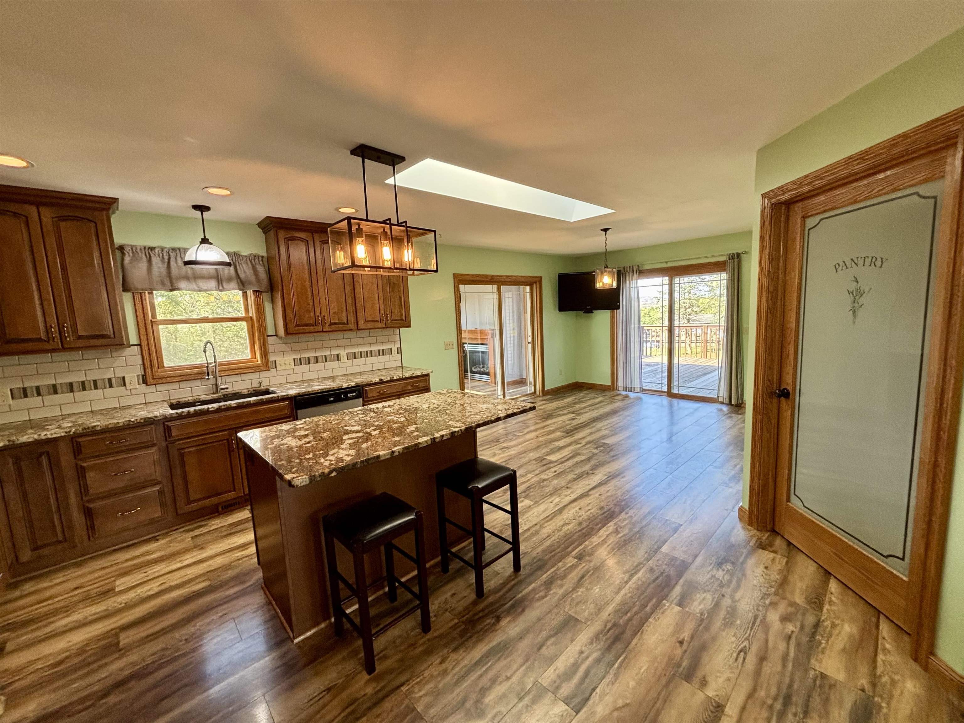 3310 South Apple River Road Elizabeth, IL 61028 - Photo 13 of 39 a kitchen with kitchen island granite countertop wooden floors and a sink