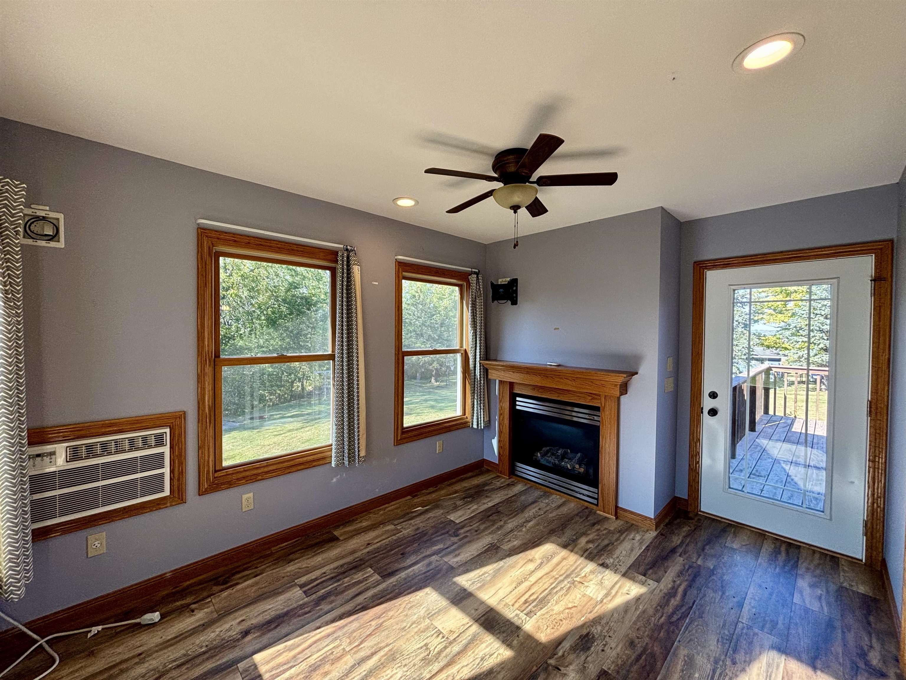3310 South Apple River Road Elizabeth, IL 61028 - Photo 18 of 39 a living room with a fireplace furniture a ceiling fan and a window
