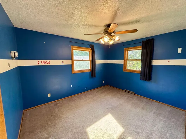 a view of a livingroom with a chandelier fan and a window