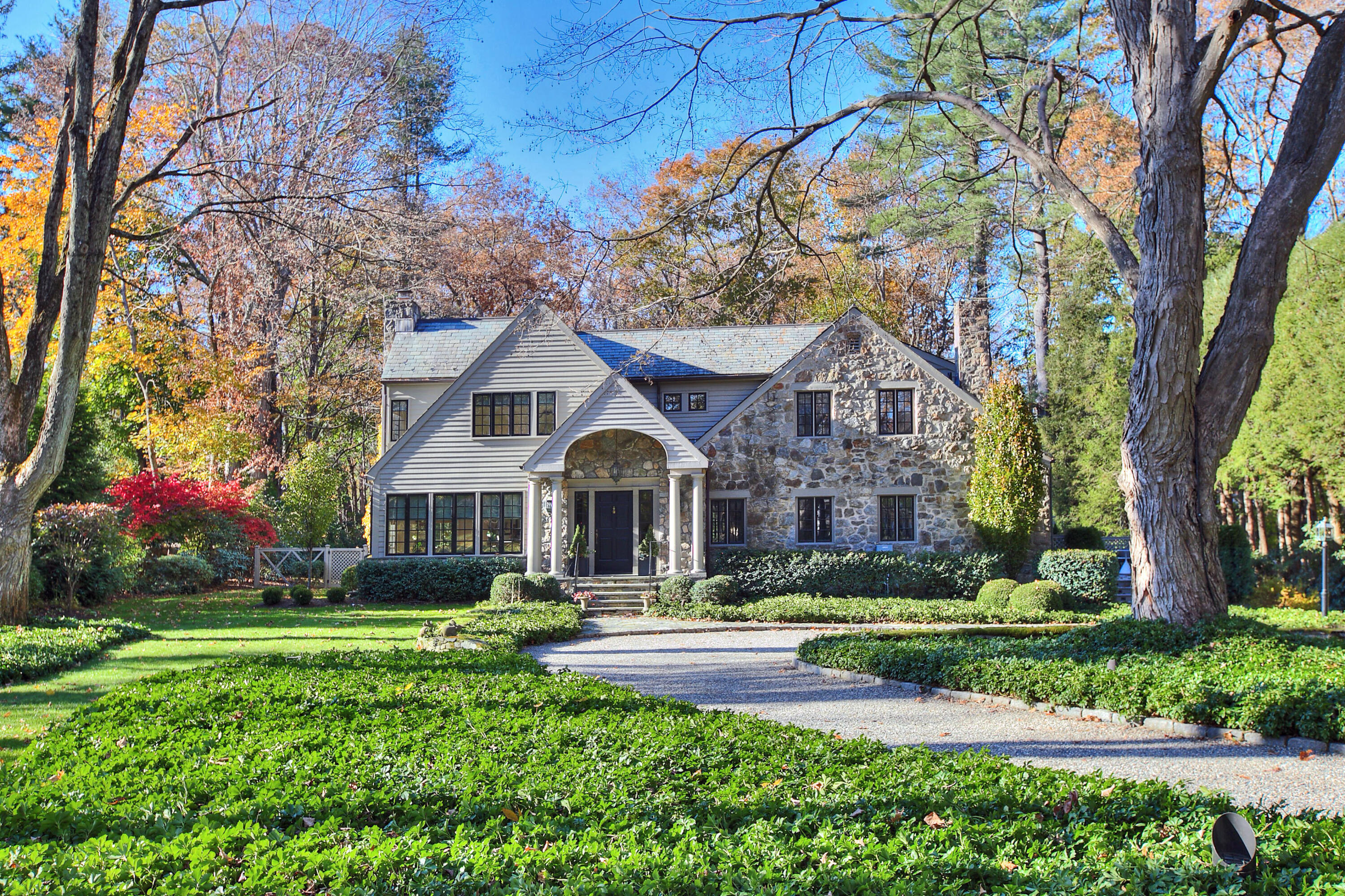 22 Mill Road New Canaan, CT 06840 - Photo 1 of 42 a front view of a house with garden and trees