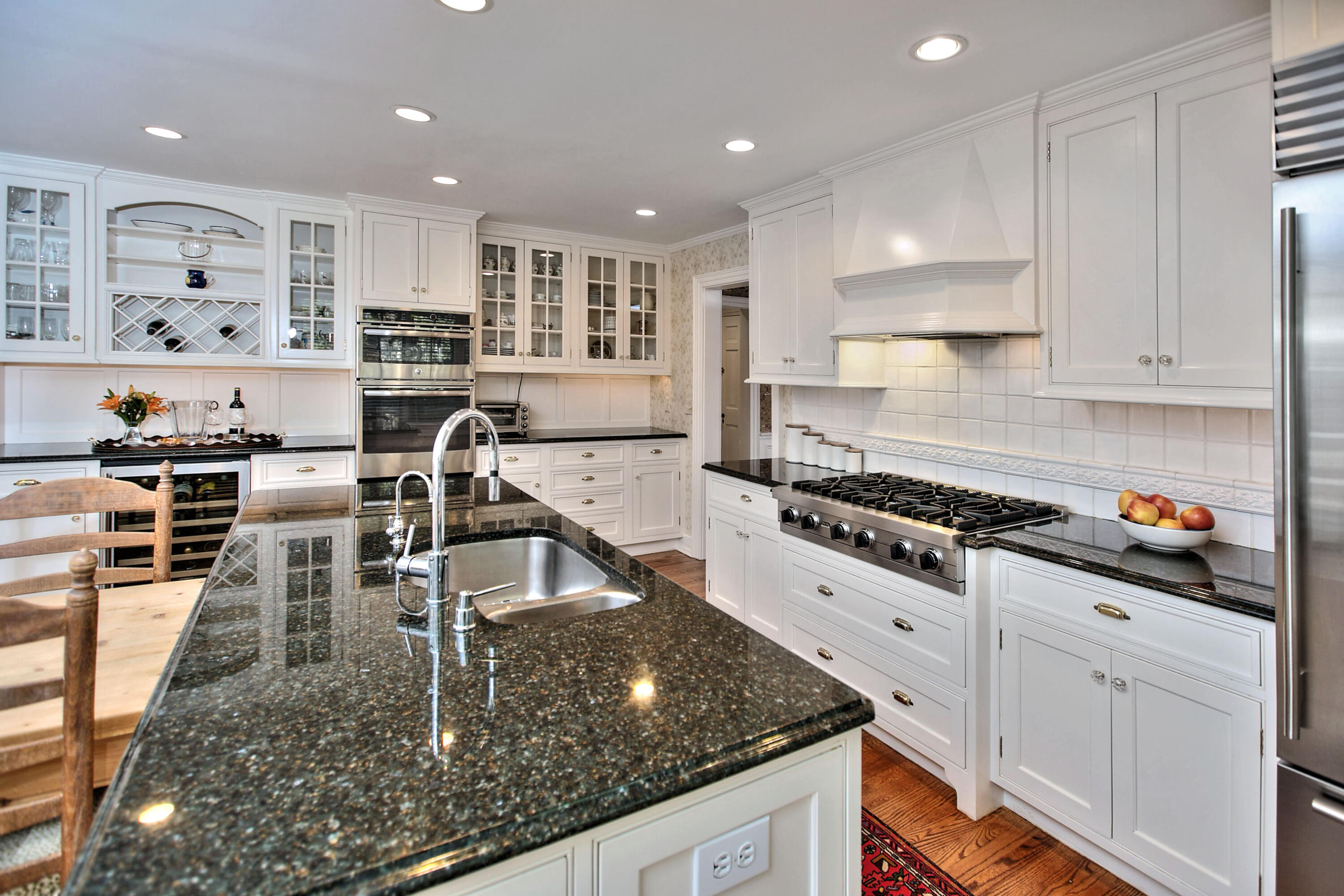 22 Mill Road New Canaan, CT 06840 - Photo 20 of 42 a kitchen with kitchen island granite countertop a sink a stove and cabinets