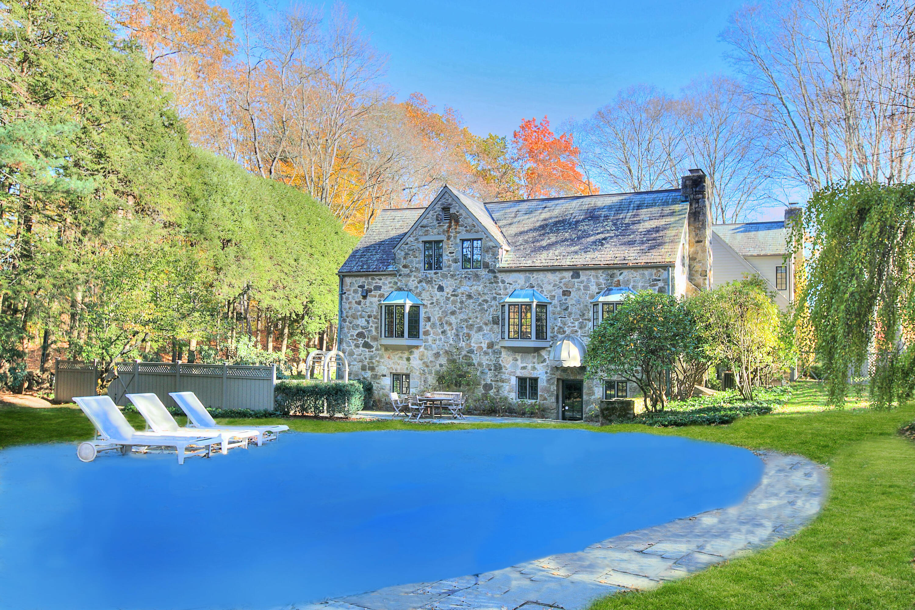 22 Mill Road New Canaan, CT 06840 - Photo 40 of 42 a front view of a house with a yard table and chairs
