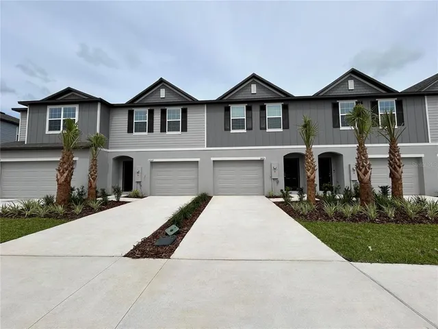 a front view of a house with yard and parking