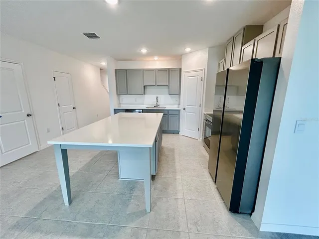a kitchen with stainless steel appliances a refrigerator sink and cabinets