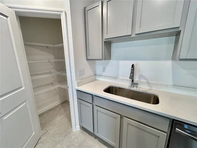 a kitchen with white cabinets and sink