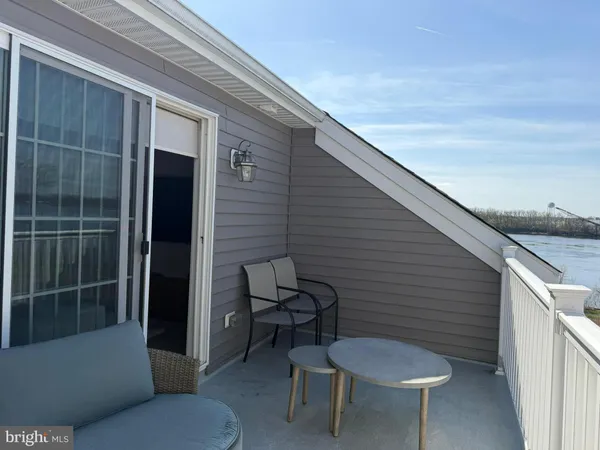 a view of a roof deck with chair and lake view