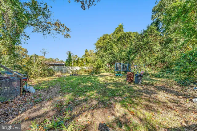 a backyard of a house with table and chairs and a large tree