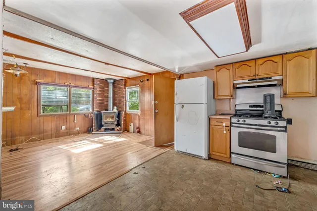 a kitchen with stainless steel appliances granite countertop a stove a refrigerator and a view of living room