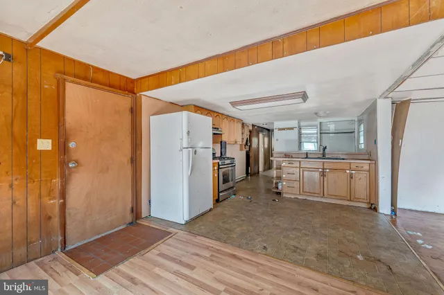 a view of a kitchen with refrigerator and white cabinets