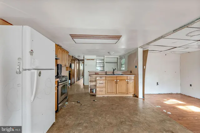 a view of a kitchen with refrigerator and cabinets