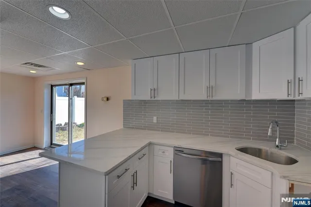 a kitchen with a sink dishwasher and cabinets