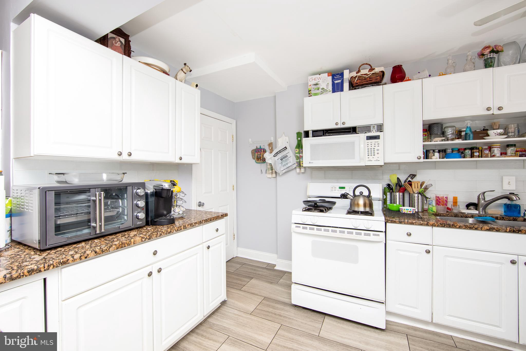 2832 Kansas Road Camden, NJ 08104 - Photo 7 of 32 a kitchen with granite countertop white cabinets and white appliances