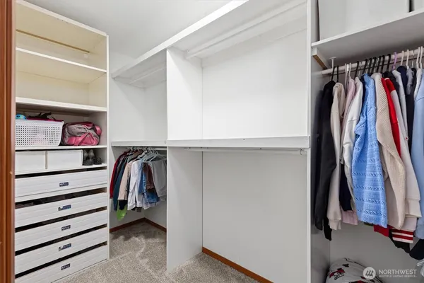 a view of walk in closet with clothes and shoes