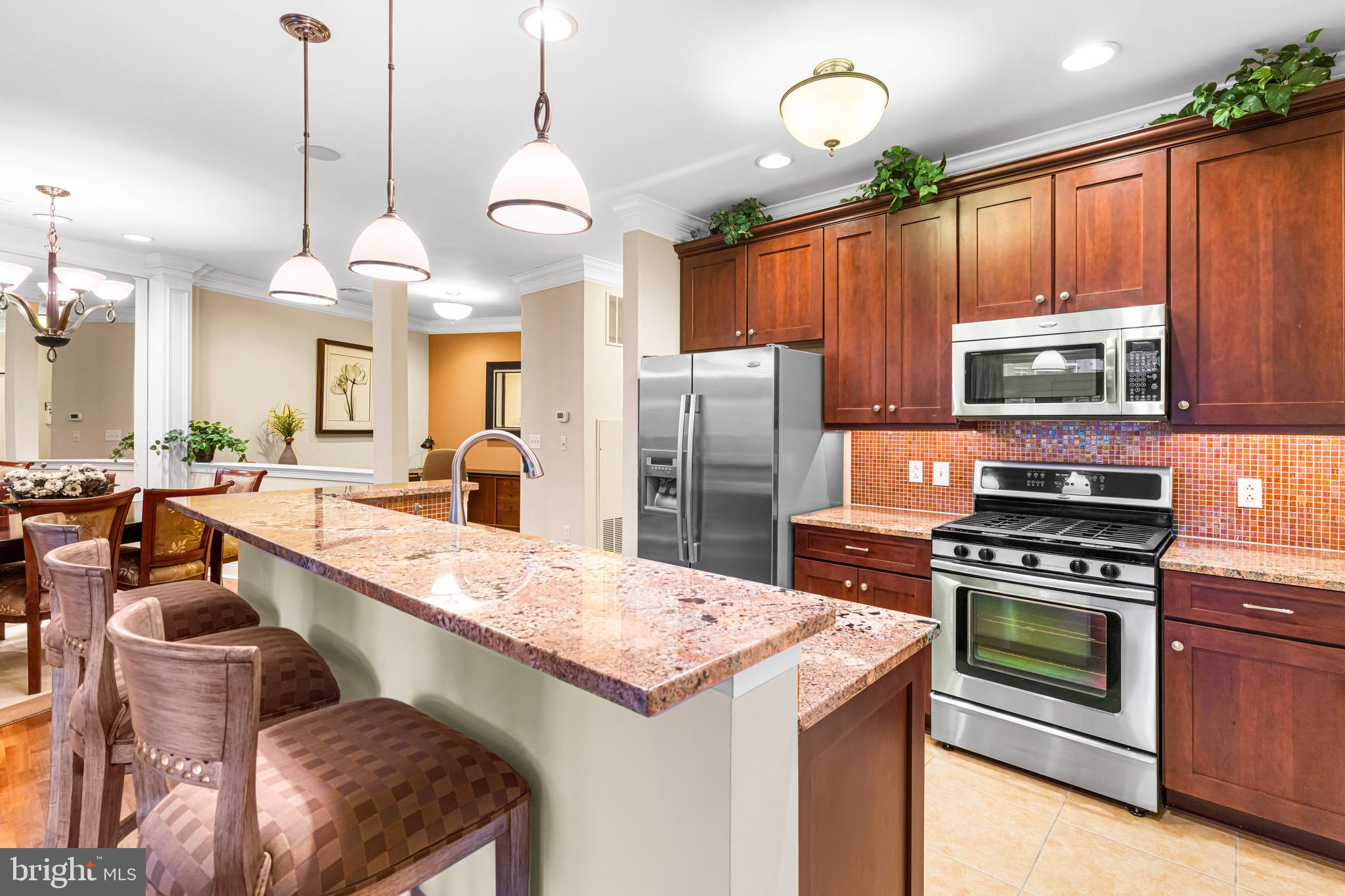 227 Carson Terrace Huntingdon Valley, PA 19006 - Photo 11 of 32 a kitchen with stainless steel appliances kitchen island granite countertop a stove a sink a refrigerator and a wooden cabinets