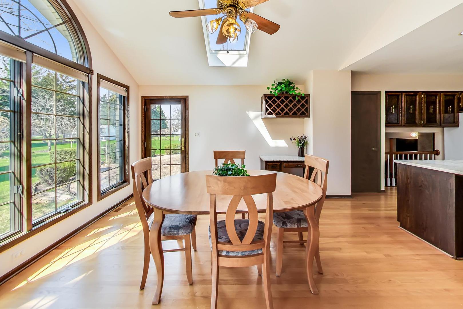 306 North Marcella Road Mount Prospect, IL 60056 - Photo 7 of 31 a view of a dining room with furniture large windows and wooden floor