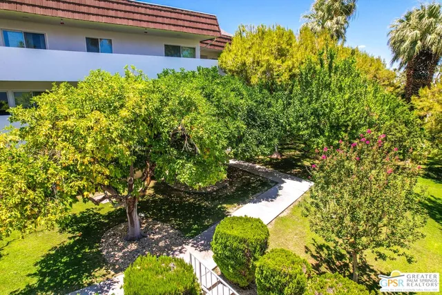 a yard with yellow house