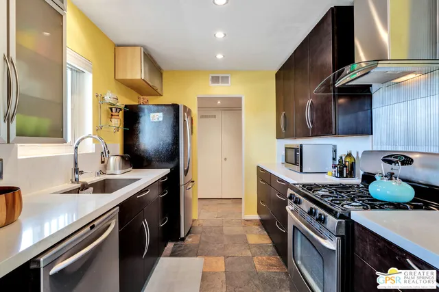 a kitchen with stainless steel appliances granite countertop a sink stove and refrigerator