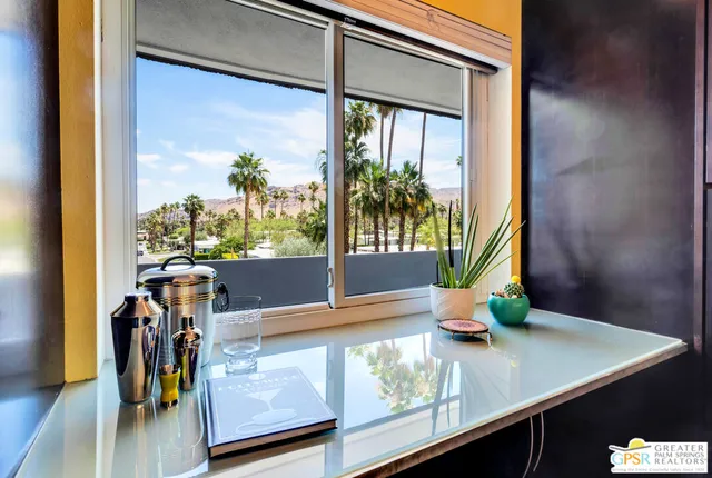 a view of a living room with a floor to ceiling window and wooden floor