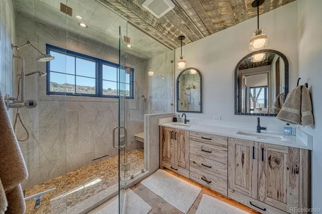 a spacious bathroom with double vanity a sink a mirror and a shower