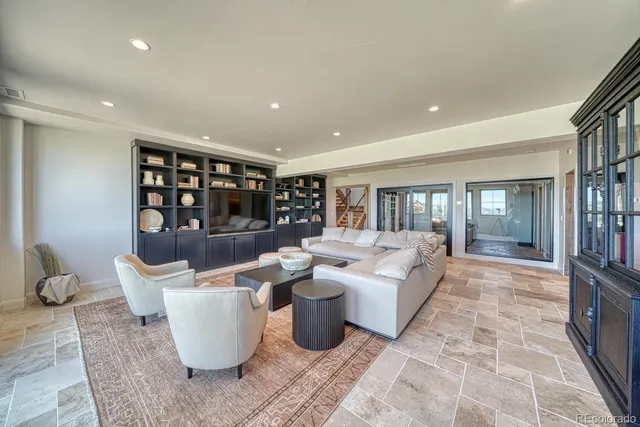 a living room with patio furniture and a potted plant