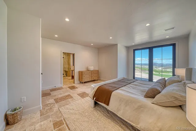 a spacious bedroom with a large bed and a large window