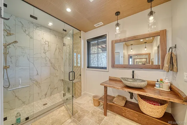 a bathroom with a sink mirror and a shower