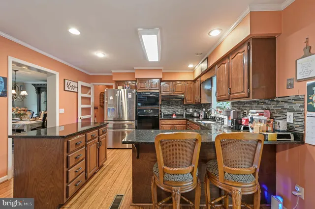 a dining room with stainless steel appliances kitchen island granite countertop a dining table chairs and view living room