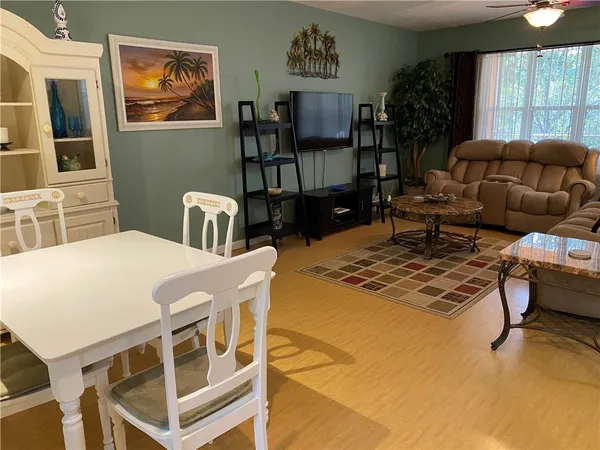 a living room with furniture a large window and a chandelier