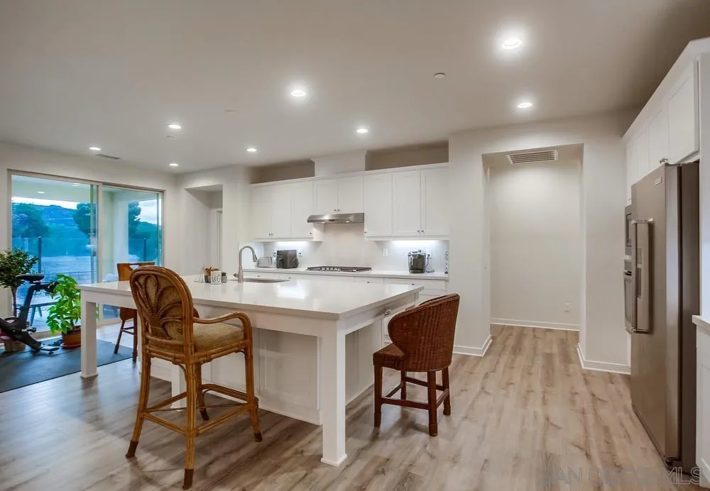 31534 Calle De Las Rosas Bonsall, CA 92003 - Photo 11 of 27 a kitchen with stainless steel appliances granite countertop a table chairs refrigerator and sink