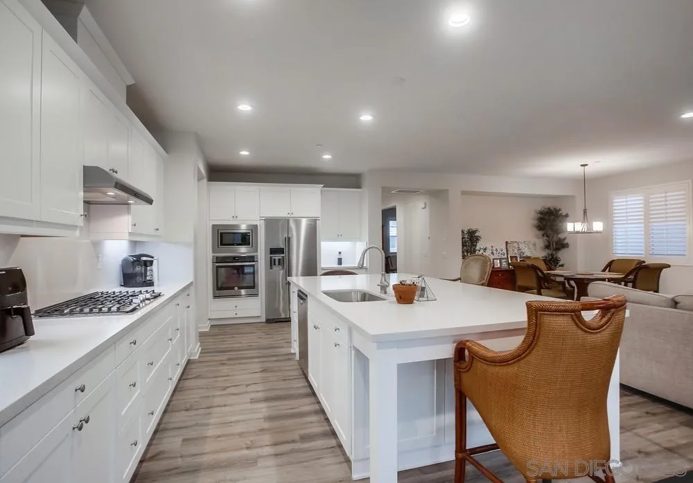 31534 Calle De Las Rosas Bonsall, CA 92003 - Photo 14 of 27 a large kitchen with stainless steel appliances kitchen island granite countertop a sink and cabinets