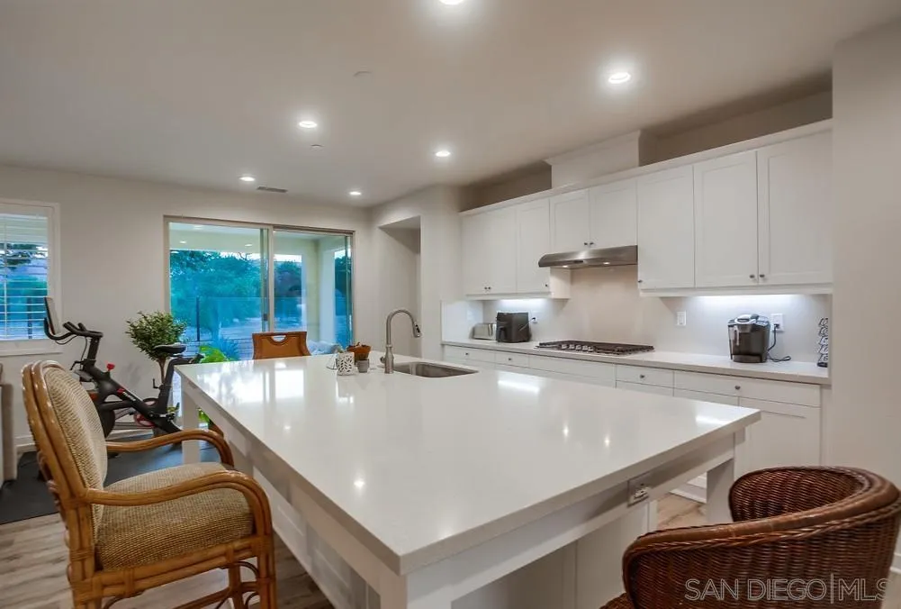 31534 Calle De Las Rosas Bonsall, CA 92003 - Photo 2 of 27 a large kitchen with kitchen island a stove a table and chairs