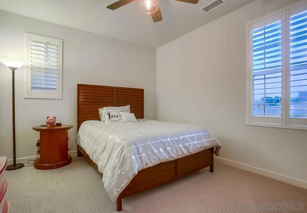 31534 Calle De Las Rosas Bonsall, CA 92003 - Photo 25 of 27 a bed sitting in a bedroom next to a lamp