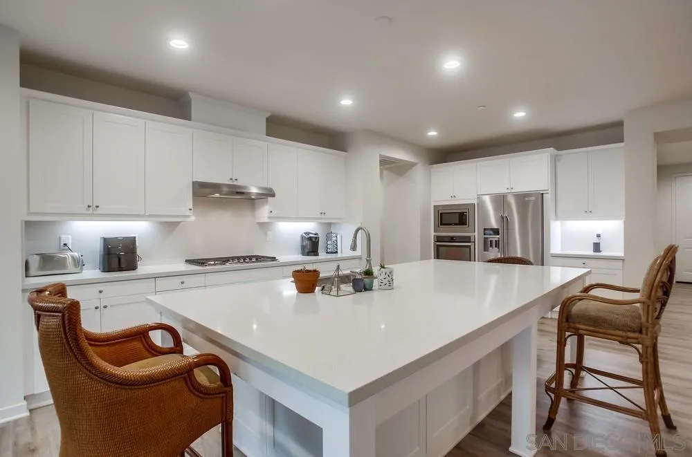 31534 Calle De Las Rosas Bonsall, CA 92003 - Photo 4 of 27 a kitchen with stainless steel appliances granite countertop a sink a stove a refrigerator and white cabinets
