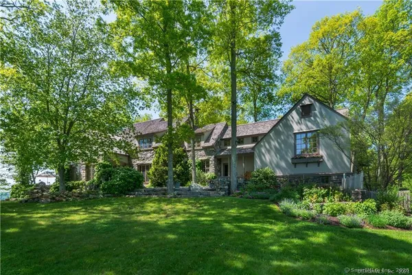 a front view of a house with a yard and trees
