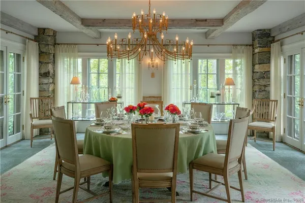 a dining room with furniture a chandelier and wooden floor