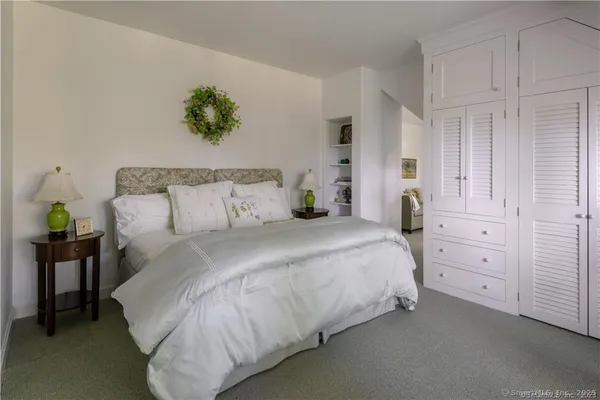 a bedroom with a bed and a potted plant