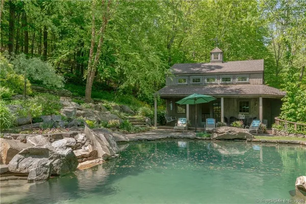a view of house with swimming pool and outdoor seating